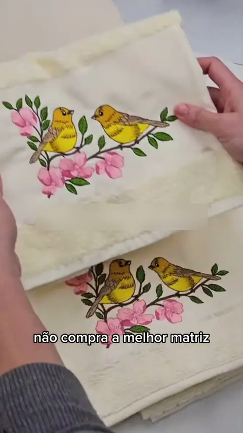 Toalha bordada com passarinhos e flores, feita com uma matriz da Biblioteca